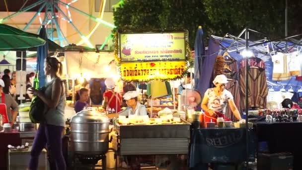Chiangmai, Thailand - November 2015:  Night temple market at Loi krattong festival. Lot of street food vendor stalls, game and ferris wheel. Local and tourist enjoying night attractions — Stock Video