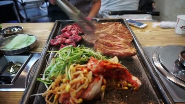 Traditionele Koreaanse barbecue en bijgerechten plantaardig voedsel. Gegrilde op grote stenen plaat — Stockvideo