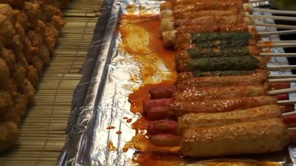 Eomuk, comida callejera coreana. Pastel de pescado frito en palo con salsa roja en Seúl, Corea — Vídeo de stock