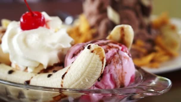 デザートのチョコレートは、バナナ、とうもろこしフレーク氷を剃毛。アイスクリームとバナナの分割 — ストック動画