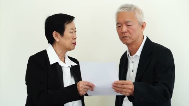 Азиатский старший бизнесмен и бизнесвумен смотрит на доклад с недовольным выражением — стоковое видео