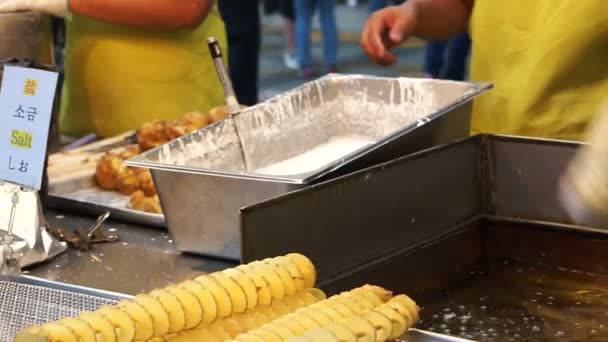 Beroemde straat voedsel over de hele wereld. Draai spiraal aardappelen. Aardappel in de bloem en gebakken in olie dompelen — Stockvideo