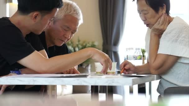 Asiatique Père et fils discutent investissement immobilier. Acheter une maison ou une copropriété. Parlant de finance, de profit et de rendement — Video