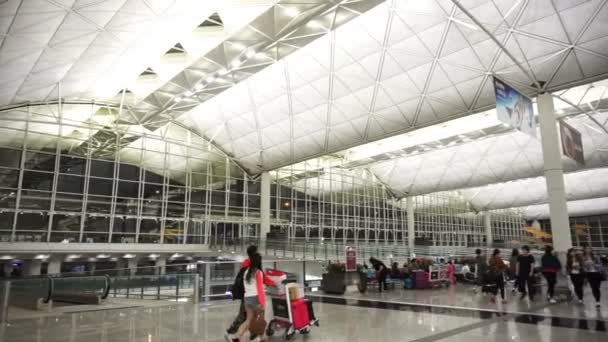 Hongkong, Čína - duben 2016: Lidé s zavazadla v odletové hale na letišti Hong Kong International Airport — Stock video