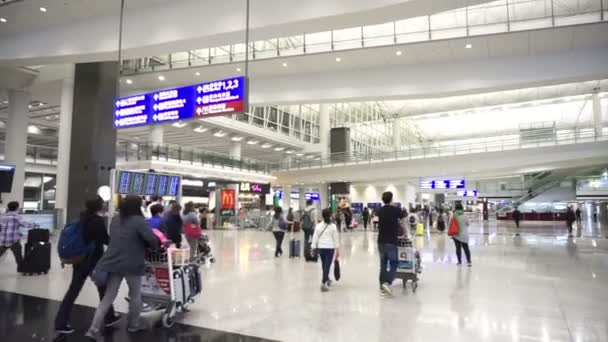 Hongkong, Čína - duben 2016: Lidé s zavazadla v příletové hale na letišti Hong Kong International Airport — Stock video