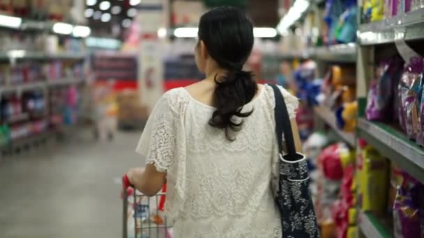 Asian girl, woman walking, looking and shopping snacks in supermarket isle — Stock Video