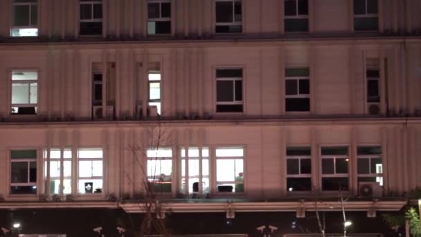 Abstrakte Überstunden am Firmengebäude mit nachts eingeschaltetem Licht — Stockvideo