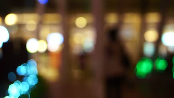 Blur holiday light bokeh background with people shadow walking — Stock Video