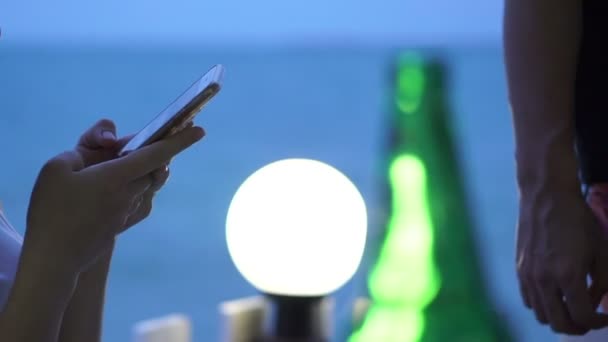 Asiatin mit Smartphone in der Abenddämmerung am blauen Ozeanstrand — Stockvideo