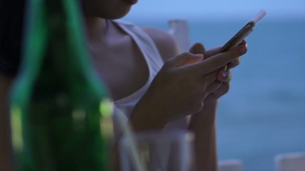 Mulher asiática com telefone inteligente durante o crepúsculo na praia azul do oceano — Vídeo de Stock