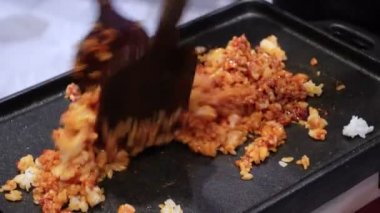 Şef tavada sosla karıştırılmış kızarmış Kore kimchi yapıyor.