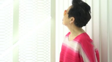 Asyalı kıdemli yaşlı kadın parlak kırmızı tonlu moda yavaş çekim