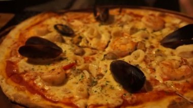 Akşam yemeğinde bir dilim İtalyan deniz mahsulü pizzası seçiyorum.