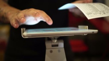 Kasiyer ödemesi için dijital tablet kullanan yakın çekim elleri