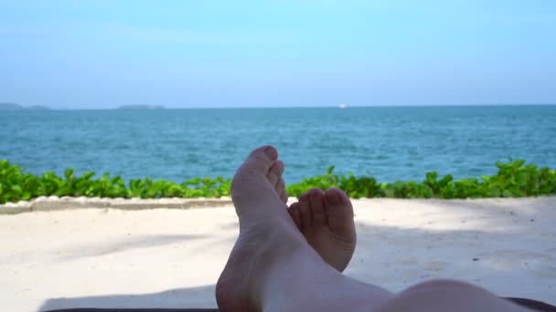 裸の足は 風景と日陰で海辺でリラックスします日当たりの良いパラダイス海の背景 — ストック動画
