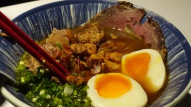 Et suyu çorbası yiyen çubuklar kızarmış sarımsaklı yeşil soğan çorbası ve haşlanmış Asya mutfağı.