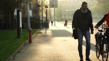 Amsterdam Hollanda 4 Nisan 2018 Yerel Kafkasyalılar kaldırımda güneş ışığında bisiklet sürüyorlar