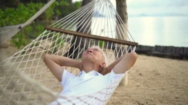 Asyalı kıdemli adam plaj tatil köyünde dinleniyor.