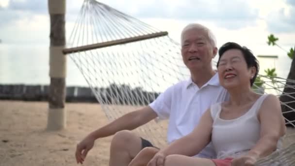 Asiático Anciano Mayor Pareja Relajarse Hablando Hamaca Playa Retiro Viaje — Vídeo de stock