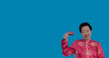 Çin 'de yeni yılı kredi kartıyla geçirmek. Constume 'daki Asyalı son sınıf öğrencisi elinde kırmızı kart tutuyor.