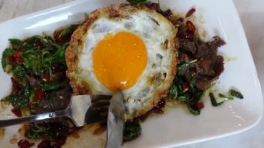 Tayland sokak yemekleri yiyorum yerel biftek, fesleğen, kızarmış biber ve yağda yumurta sarısı.