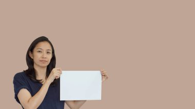 Dost canlısı karışık ırk gelişigüzel Asyalı olgun kadın fotokopi alanı reklamlarıyla jest yapıyor.