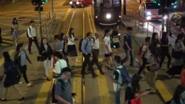 Hong Kong, 23 Oct 2019: People pedestrian crossing city street at night with tram scene local and tourist life population