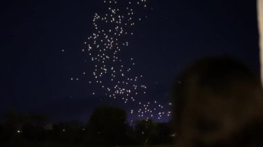 Kadın, Tayland 'da gece karanlığında yüzen binlerce feneri uzaktan görüyor.