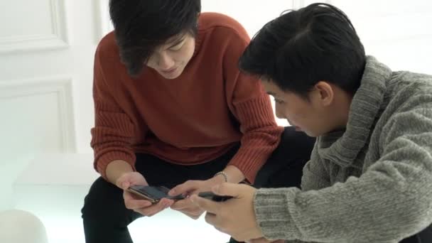 Dwóch Azjatyckich Przyjaciół Dzielących Się Zakupami Informacjami Technologicznymi Przez Telefon — Wideo stockowe