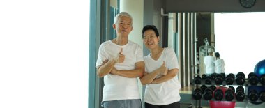 Asyalı son sınıf çifti spor salonunda birlikte egzersiz yapıyor. Yaşam tarzı sağlık hizmetleri üzerinde çalışıyor.