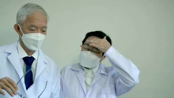 两名亚洲资深医生讨论病人信息数据表在垫子情况下是相当致命的 — 图库视频影像