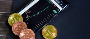 crypto currency with price graph in smart phone application gold and copper coins