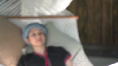 Sakin ol Etnik Tepe Kabilesi kızı sabahtan sonra hamakta kestiriyor. Geleneksel giysiler giyiyor.