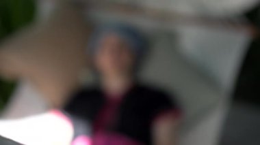 Sakin ol Etnik Tepe Kabilesi kızı sabahtan sonra hamakta kestiriyor. Geleneksel giysiler giyiyor.