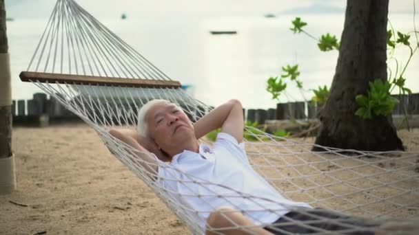 Старший Азиатский Мужчина Расслабляется Песчаном Пляже Тропической Мечты Пенсионной Жизни — стоковое видео