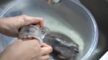 El, kalamar kemiğini vücudundan ayırarak deniz ürünleri hazırlıyor.