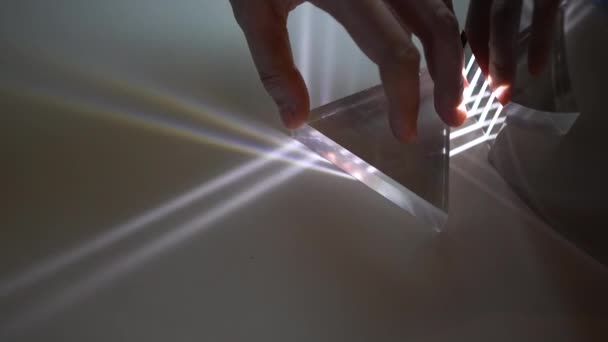 光の歪みと虹のスペクトル効果を示す手の回転プリズム実験 — ストック動画