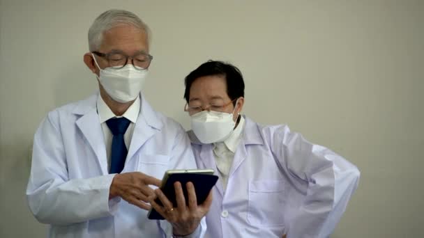 亚洲老年男女医生使用平板电脑定制医院个人信息 — 图库视频影像
