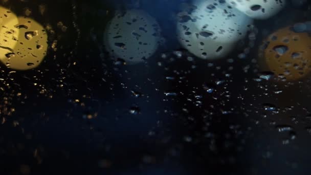 Abstrakt oskärpa trafik belysning i regnet med bokeh — Stockvideo