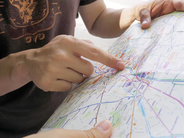 Male tourist pointing in map