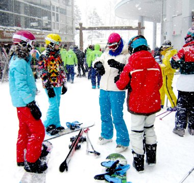 Tourists of ski resort  in high season clipart