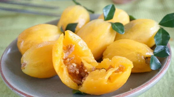 Orange plum fruits stuffed with meat — Stock Photo, Image