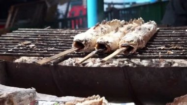 Yanan üzerinde tuz ile kömür ızgara yılanbaşı balık