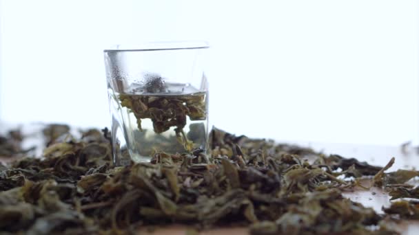 Hojas de té disueltas en agua caliente — Vídeos de Stock