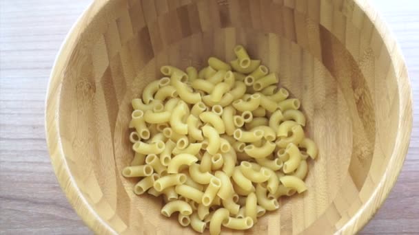 Verter macarrones en un plato de madera — Vídeo de stock