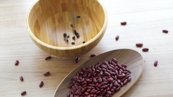 Red and black beans pouring to fill the bowl — Stock Video