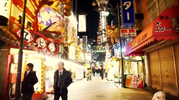 OSAKA, JAPÓN - MARZO 2015: Tiendas luces de área con fondo Torre Tsutenkaku, antigua zona comercial clásica en Osaka, Japón . — Vídeo de stock