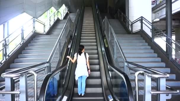 Девушка-путешественница на эскалаторе общественного транспорта — стоковое видео