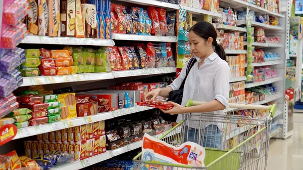 Chica asiática, mujer compras bocadillos en el supermercado — Foto de Stock