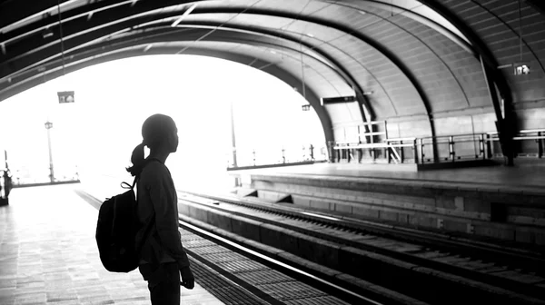 Sylwetka na turystyczny backpacker dziewczyna czeka na pociąg w — Zdjęcie stockowe